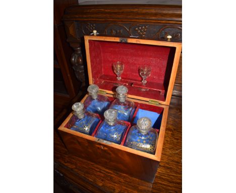 A 19th Century mahogany decanter box, the domed front lid opening to reveal five glass decanters (one missing); and two glass