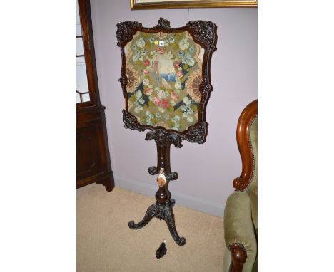 A 19th Century heavily carved and stained wood pole screen with a rectangular screen in ornate wood frame with decorative nee
