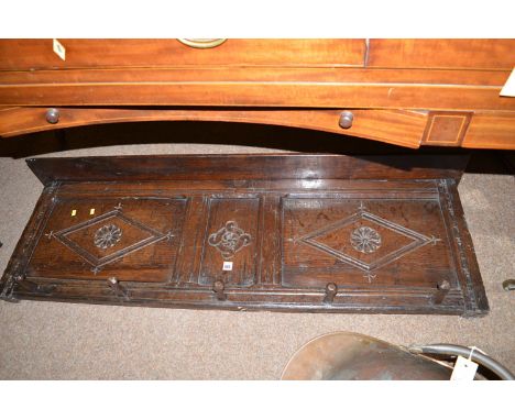 A carved and stained oak coat rack made from an antique carved oak panel, fitted with five carved coat hooks.
