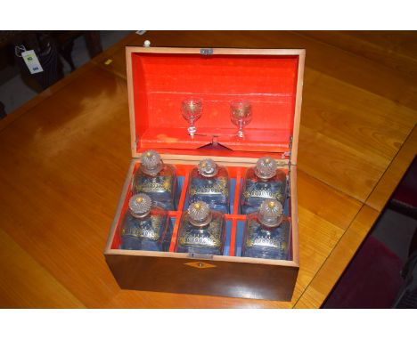 A 19th Century mahogany decanter box, the domed front cover opening to reveal six associated decanters and two glasses (one s