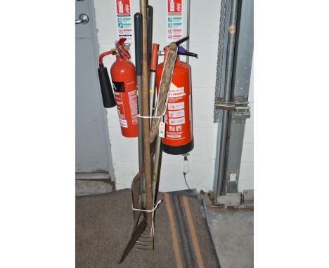 A bundle of tools including a rake and a shovel.