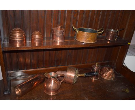 A 19th Century copper scoop with ebonised handle; three copper food moulds; a harvest measuring jug; and tea caddy; together 
