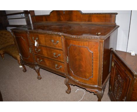 An early 20th Century large mahogany sideboard, the shaped top with shaped back panel and moulded edge above three central dr