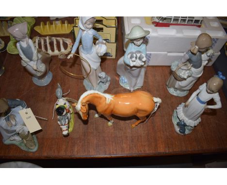 A Lladro figure of a girl and a lamb; five Nao figures; a Beswick palomino horse; together with a Beswick Thelwell horse and 