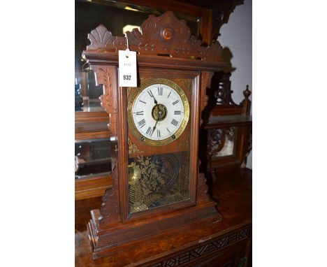 A 19th Century American mantel clock in carved and stained wood case.
