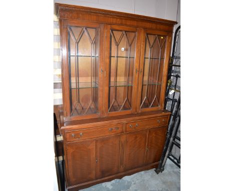 A reproduction inlaid mahogany bookcase with three glazed astragal doors, fitted two frieze drawers, the cupboards below rais