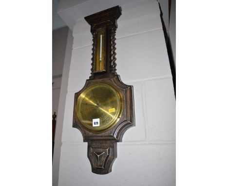 Aneroid barometer and thermometer in stained oak banjo pattern case with decorative spiral twist columns. 