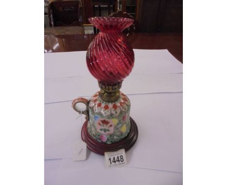 A porcelain chamber oil lamp with red glass chimney.Small chip to bottom rim, Chip to shade rim.