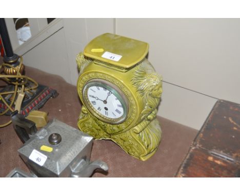 An Art Nouveau style green glazed mantel clock- key and pendulum on rostrum 
