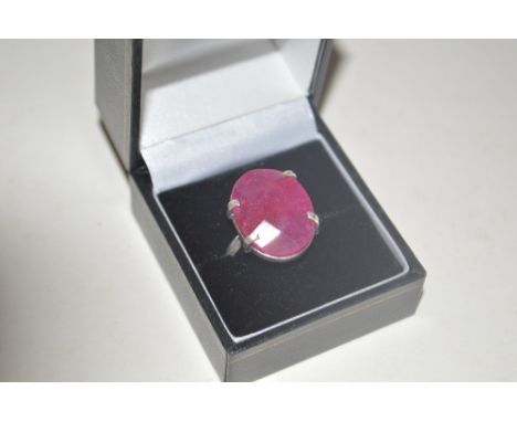 A white metal ring set with ruby coloured stone