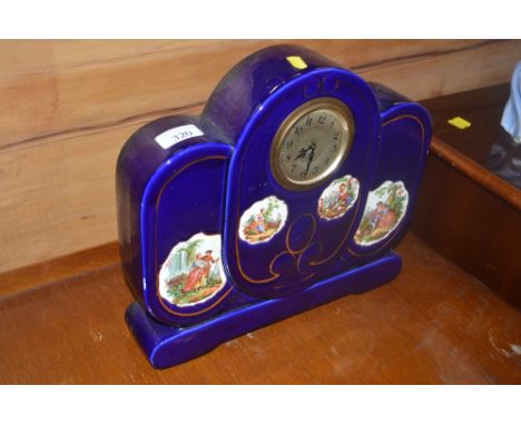 A blue glazed mantel clock with figural decoration