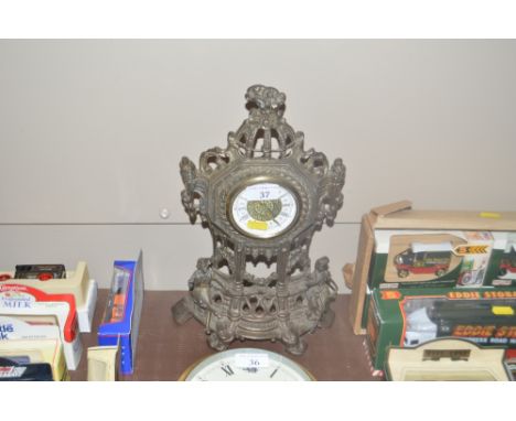 A cast metal cased mantel clock with figural decoration