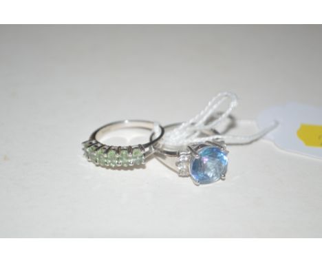 A silver green stone set dress ring and a white metal blue stone ring