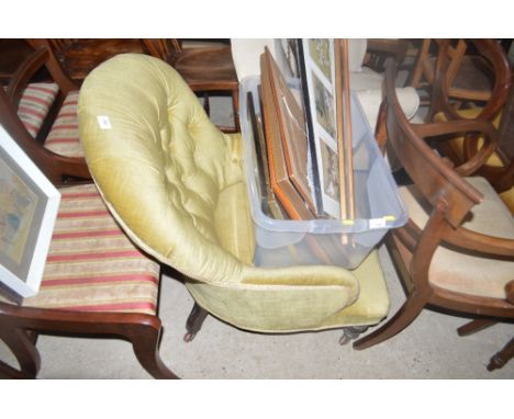 A late 19th Century green upholstered button back armchair raised on mahogany legs 