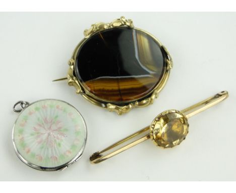 A floral enamel silver locket, 28mm across,
a topaz set bar brooch and an agate set brooch, (3).