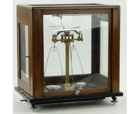 A Baird & Tatlock laboratory balance scale 
in glazed case, height 18" overall.