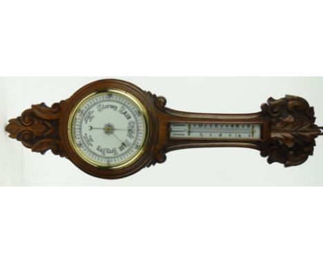 A carved oak cased aneroid wall barometer
with thermometer, 34".