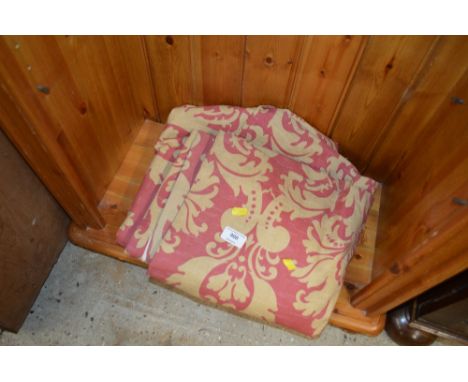 A pair of red and gold lined curtains 