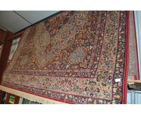 A large Persian style floral patterned carpet