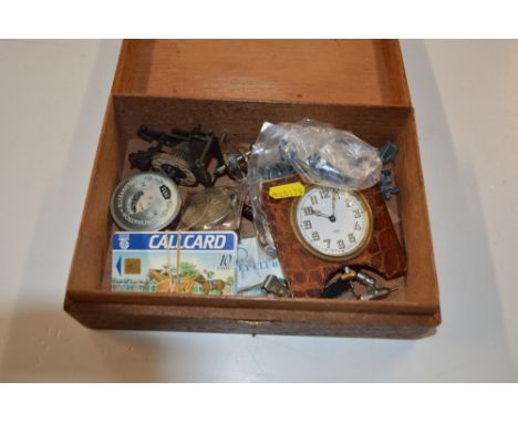 A wooden box containing coinage, phone cards, an alarm clock etc. 