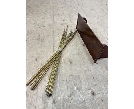 An Edwardian mahogany wall hanging shelf with shaped bracket supports and twenty two various brass stair rods (shelf: 21cm x 