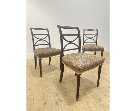 A set of three Regency mahogany scroll back side chairs with machine made tapestry upholstered seats, on fluted tapered suppo