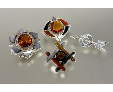 A collection of four Scottish style white metal pebble set brooched to include and arrow and target&nbsp; L x 5cm, a dark cir