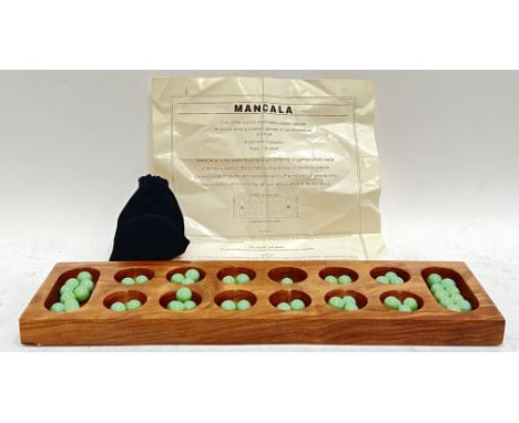 A carved hardwood Mancala game with jade-coloured glass markers and carry bag/instructions (w- 44cm)