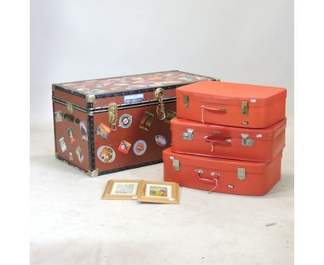 A red travelling trunk, 100cm, together with a pair of prints and three red suitcases (6)