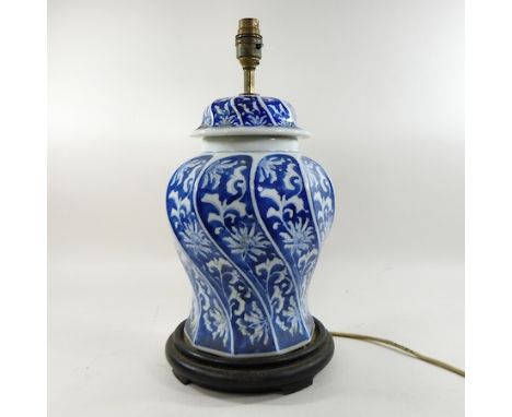 A 19th century Chinese blue and white porcelain table lamp, on a hardwood stand, 42cm high overall