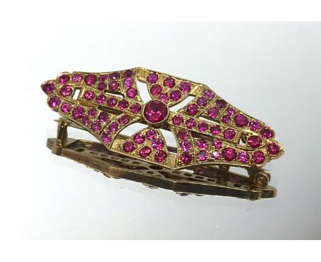 A yellow metal and ruby style brooch, unmarked.
