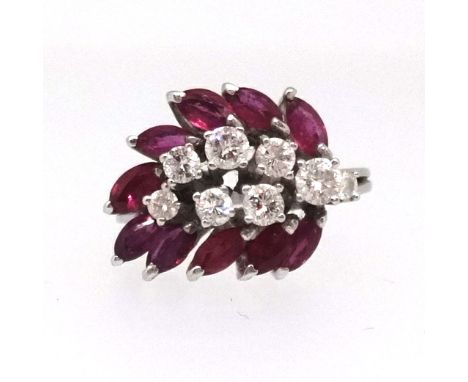 A good ruby and diamond ring set with an arrangement of eight round cut diamonds in a form of a stylised leaf surrounded by t