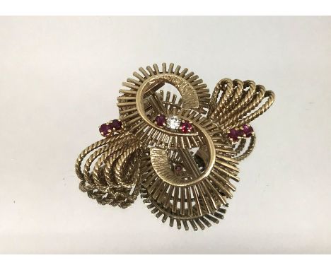 A 9ct gold ruby and diamond set swirl brooch, weight 10.1gms.