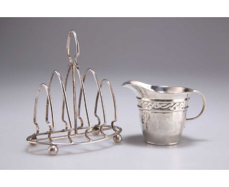 AN ARTS AND CRAFTS SILVER CREAM JUG AND A GEORGE V SILVER TOAST RACK the cream jug by W H Haseler Ltd, Birmingham 1911; the f