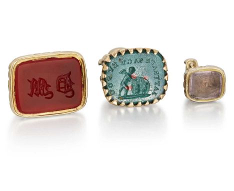 THREE INTAGLIO FOB SEALS comprising a bloodstone example, carved with a putti and globe; a monogrammed carnelian example; and
