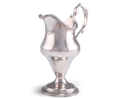A GEORGE III SILVER CREAM JUG by Charles Chesterman, London 1783, helmet-shaped with beaded rims and scroll-form handle. 13.5