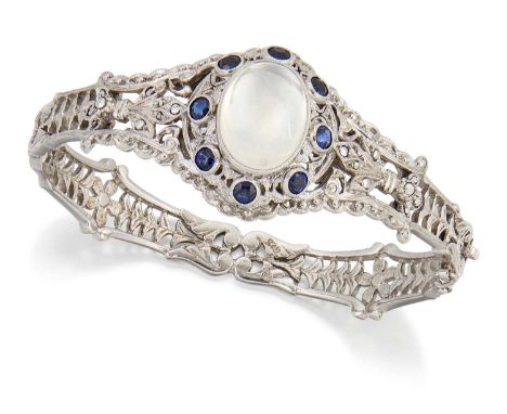 A MOONSTONE, SYNTHETIC SAPPHIRE AND MARCASITE HINGE OPENING BANGLE an oval moonstone within a fancy pierced border of synthet