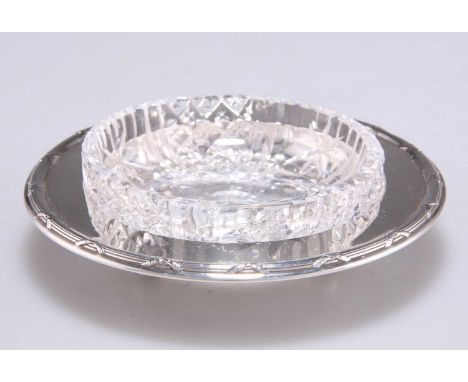 A GEORGE V SILVER AND CUT-GLASS TRINKET DISH by John &amp; William F Deakin, Sheffield 1911, circular, with a ribbon-tied ree