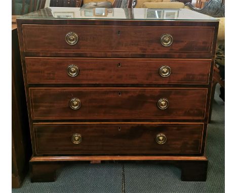 A Georgian straight fronted chest of drawers with string inlay, four graduated drawers with twin hoop handles, on bracket fee