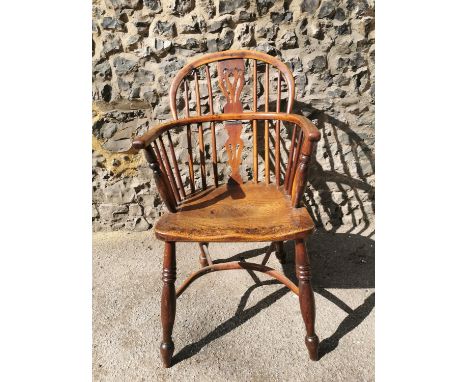 A Georgian ash and elm comb back Windsor armchair with pierced central splat turned legs and crinoline stretcherCondition rep