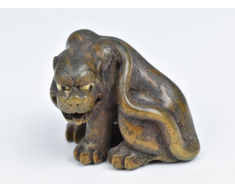 A Japanese finely carved wood netsuke, 19th century, modelled as a snarling tiger, with ivory eyes, the body with fine textur