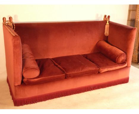 A large burgundy upholstered Knoll Sofa, gold braiding and tassels with two cushions, approx. 200cm wide 