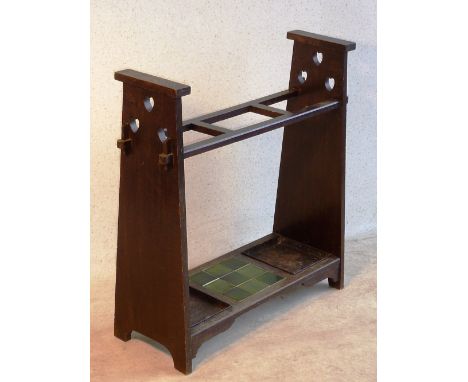 An early 20th Century Arts and Crafts oak Stick Stand in Liberty & Co., style, the tapering vertical supports each pierced wi