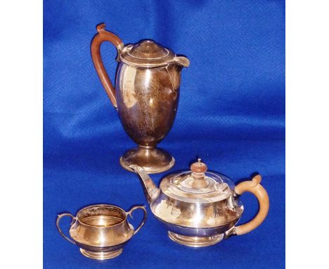 A three piece hallmarked silver Tea Service comprising Tea Pot of squat bun shape, baluster shaped Hot Water Jug (minus finia