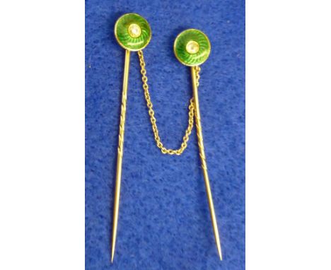 An unusual pair (joined by a single central chain) of yellow metal Stick Pins, each finial with a central diamond surrounded 