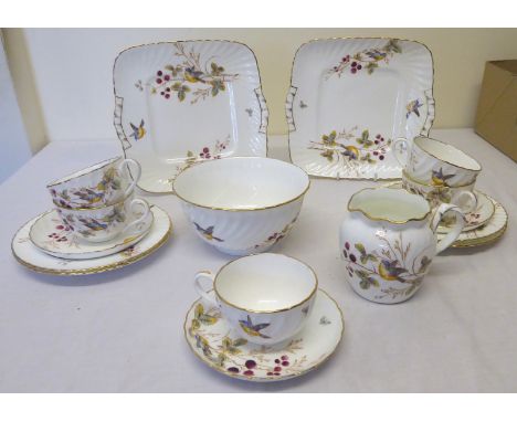 A late Victorian Tea Set decorated with birds and flowering branches comprising; twelve cups and saucers, twelve plates, milk