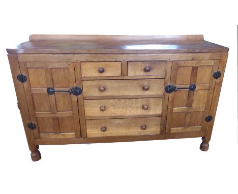 A Thompson of Kilburn "Mouseman" adzed oak Sideboard with three long and two short centre drawers flanked by a pair of panell