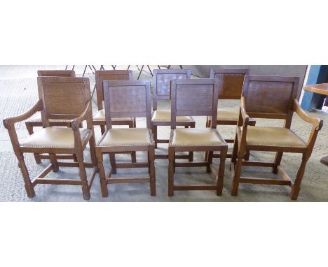 A set of eight Thompson of Kilburn "Mouseman" adzed oak panel back Dining Chairs with hide seats and carved mouse signatures.