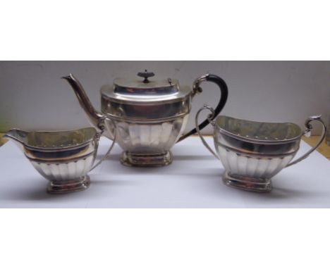 A silver three piece Teaset of oblong design with half body panelled decoration, the teapot with blackwood handle and lift, S