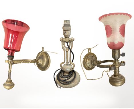 A brass ship's gimbal table lamp, and two further gimbal wall lights, one with cranberry glass shade, the other with a two-to